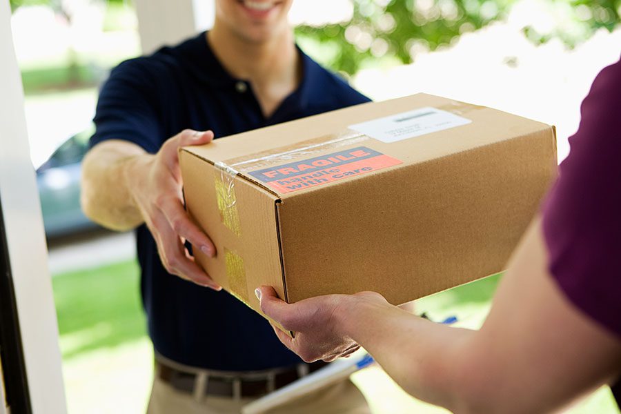 Parcel Delivery Contractor - Insurance Quick Delivery Man Handing a Package to a Homeowner